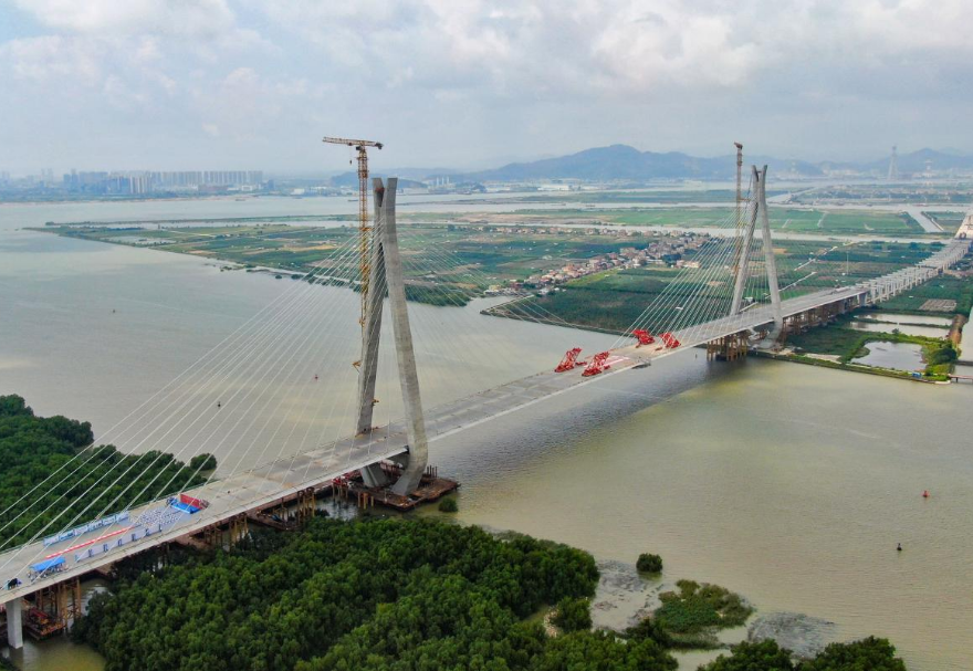 南中高速連通廣州、中山、深圳三市，是國家高速公路網(wǎng)G2518和廣東省高速公路網(wǎng)S78的重要組成部分，也是粵港澳大灣區(qū)重大交通基礎(chǔ)設(shè)施項目。其中的洪奇門特大橋全長1126米，為主跨520米的雙塔雙索面鋼箱梁斜拉橋，是南中高速項目的關(guān)鍵控制性工程。2023年5月21日上午，南中高速洪奇門特大橋順利合龍，實現(xiàn)了廣州、中山兩市實現(xiàn)跨江“牽手”。圖為南中高速洪奇門特大橋。
