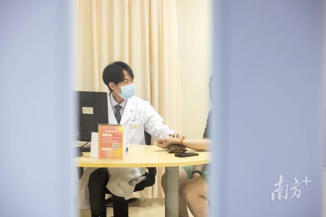 梁偉衡在給病人看診。