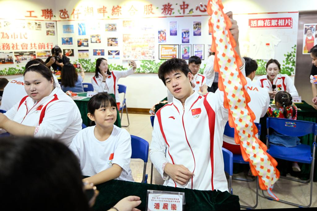 9月2日，在澳门工联氹仔湖畔综合服务中心，游泳运动员潘展乐（右）展示与小朋友一起制作的灯笼。当日，内地奥运健儿代表团走进澳门社区，分别到妇联乐满家庭服务中心、街总石排湾家庭及社区综合服务中心和工联氹仔湖畔综合服务中心与市民互动。新华社发