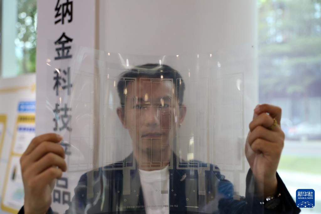 11月25日，在橫琴澳門青年創(chuàng)業(yè)谷，納金科技有限公司工作人員展示一張柔性透明導(dǎo)電材料
