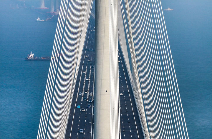 黃茅?？绾Ｍǖ勒酵ㄜ嚭?，車輛行駛在黃茅海大橋上（2024年12月11日攝，無(wú)人機(jī)照片）。新華社記者 劉大偉 攝