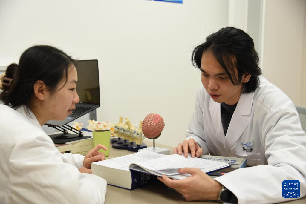 澳門醫(yī)生繆永銳（右）和同事進(jìn)行交流（12月17日攝）。新華社記者 洪澤華 攝