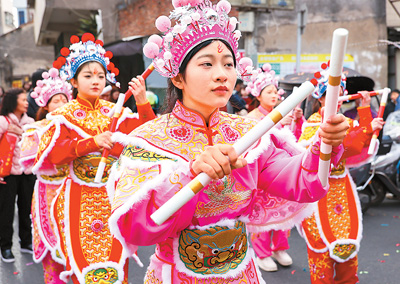  春節(jié)期間，英歌舞隊(duì)員在廣東省汕頭市潮陽(yáng)區(qū)海門鎮(zhèn)街頭巡游表演。王文攝（人民視覺(jué)）