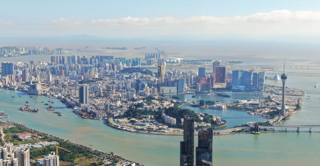 從珠海市區(qū)拍攝的澳門及遠(yuǎn)處的港珠澳大橋（2024年11月26日攝，無(wú)人機(jī)照片）。新華社記者 鄧華 攝