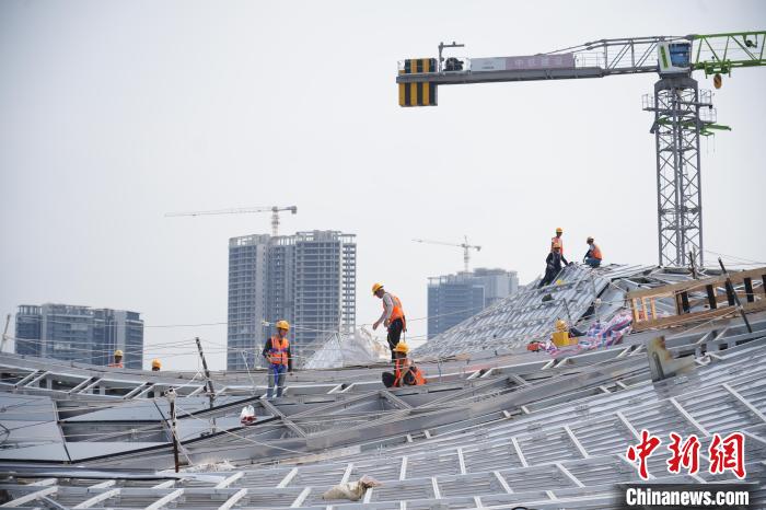建設(shè)者們忙于幕墻工程、金屬屋面、機(jī)電安裝、精裝修施工。記者 韋杰夫 攝