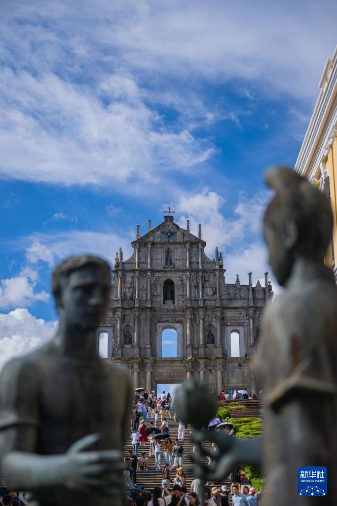 8月21日，旅客在澳门大三巴牌坊前游览。新华社发 （张金加摄）